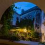 Inner courtyard of Plankenstein Castle at dusk, illuminated with warm light, surrounded by ivy and old walls.