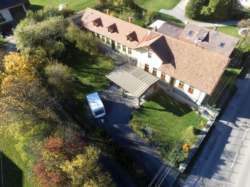 Aerial view of a house with garden and vacation apartments at the back.