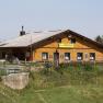 A traditional wooden building in an alpine landscape with the inscription 'Almreserhaus'.