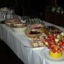 Buffet with desserts and fruit skewers on a table.