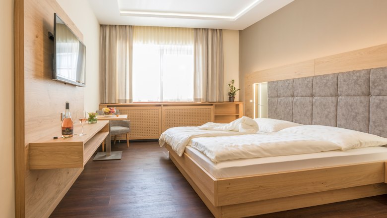 Guest room, © Fam Breitenfelder / Podolsky Modern guest room with double bed, flat screen TV and wooden furniture.