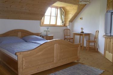 Cozy bedroom with wooden furniture and skylight.