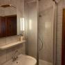 Bathroom with shower, washbasin and mirror with lighting.