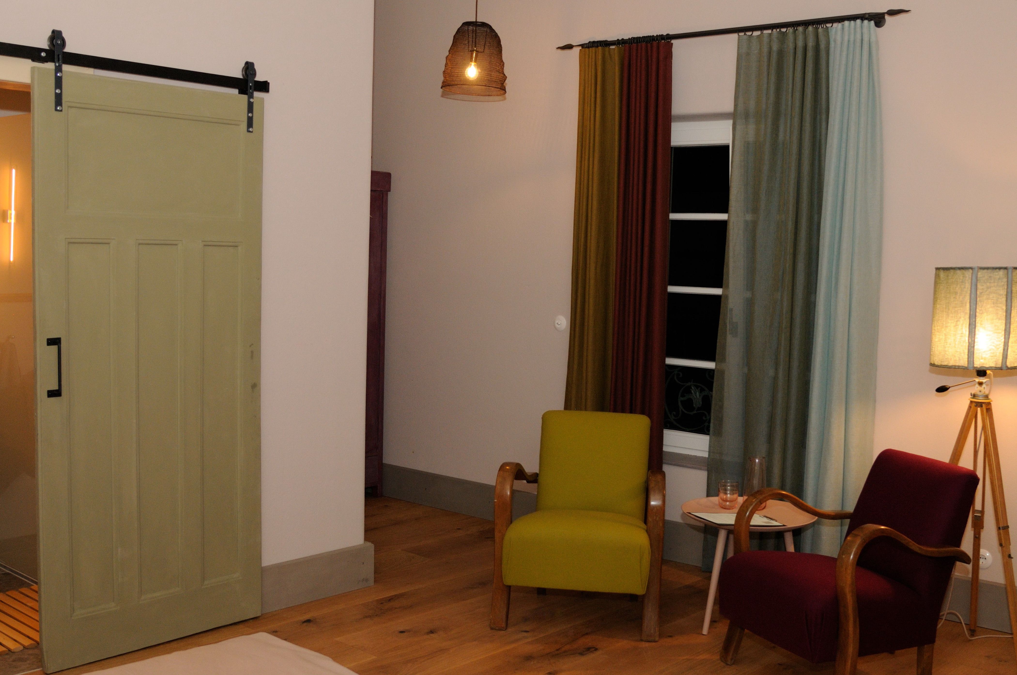 Cozy room with two armchairs, curtains and floor lamp.