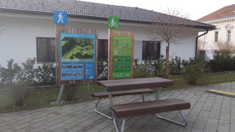 A rest area with information boards for hikers and cyclists in Pitten.