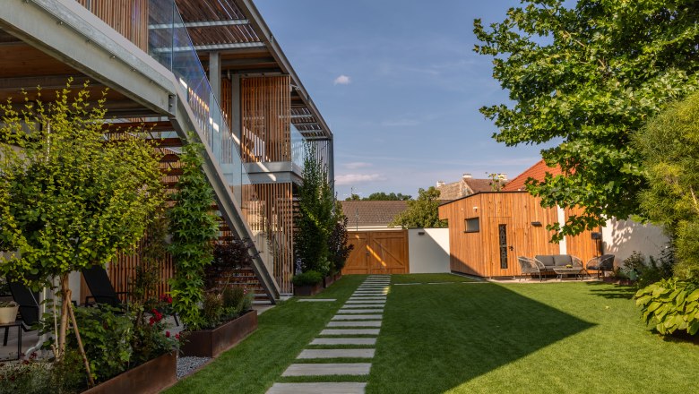 Modern apartment complex with garden and wood paneling.