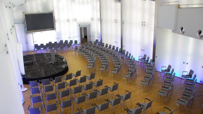 Modern conference hall with rows of chairs and stage in Schloss Rothschild, Kristallsaal.