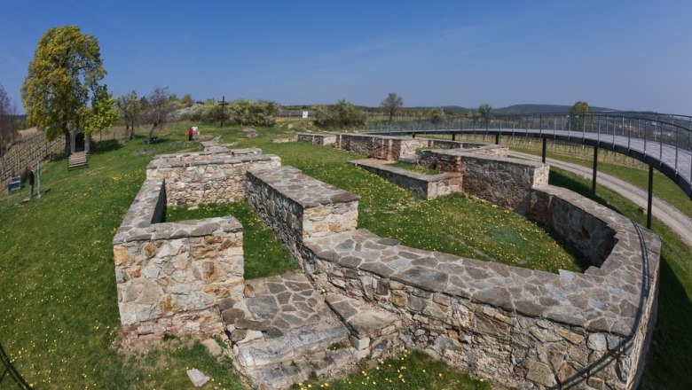 Excavation site with stone walls and outdoor viewing platform.