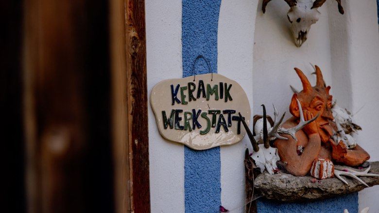 Entrance to a ceramics workshop with a sign and decorative elements.