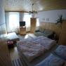 Cozy bedroom with double bed, sofa, TV and wooden furniture in a vacation apartment.