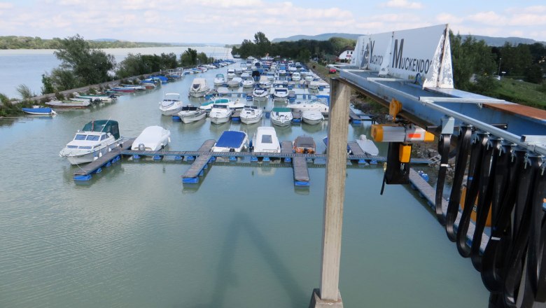 Yacht club Muckendorf with many boats at the jetty and a crane in the foreground.
