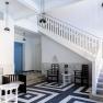Modern entrance area with staircase, black and white tiles and minimalist furniture.