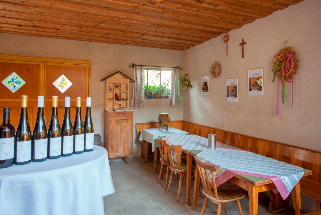 Tasting room at the Piewald winery with wine bottles on a table and rustic furnishings.