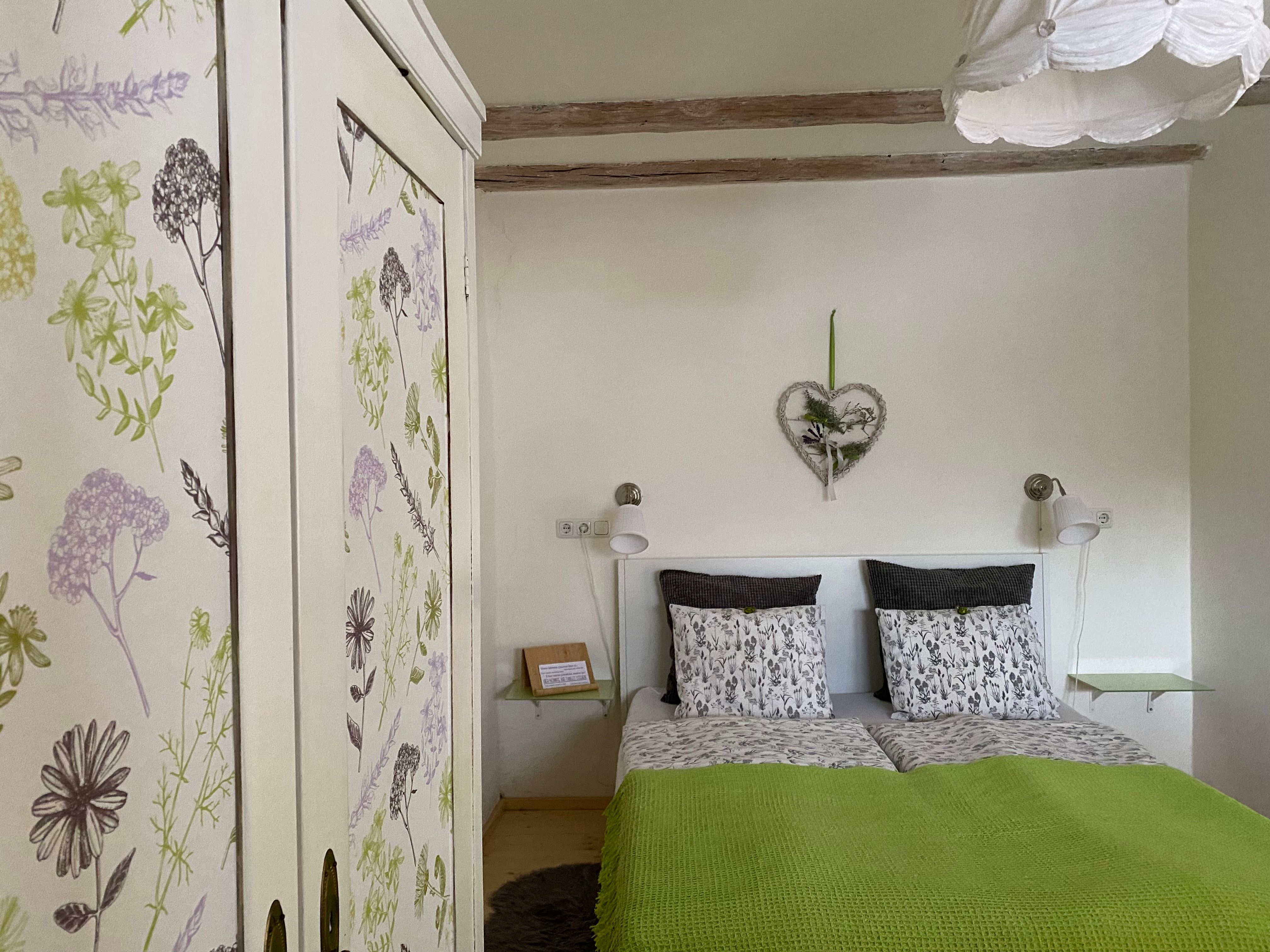 Cozy double room with floral closet and green comforter.
