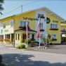 Yellow country inn hotel with flower boxes and Austrian flags.