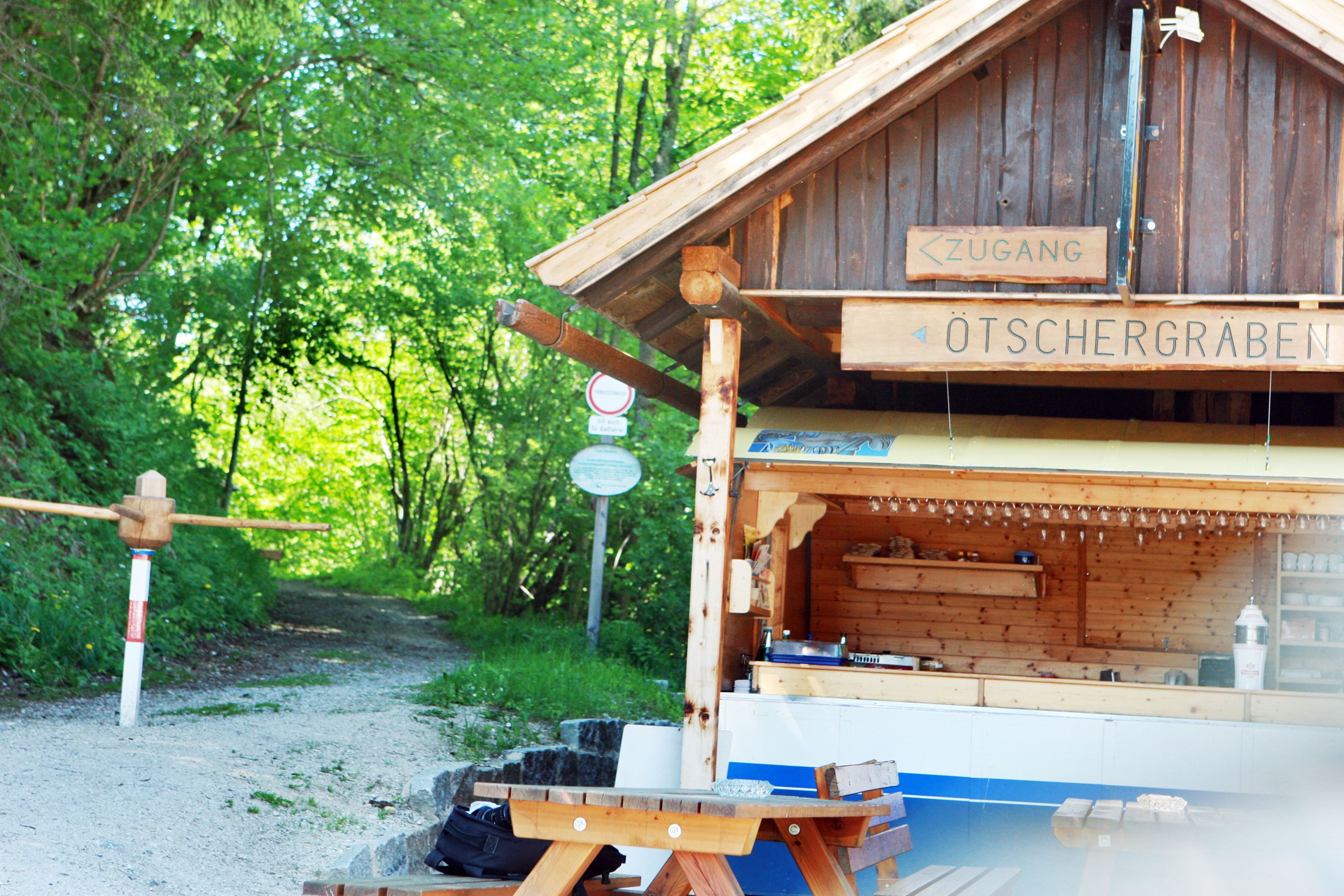 Wooden hut with 'Ötschergräben' sign and forest path in the background.