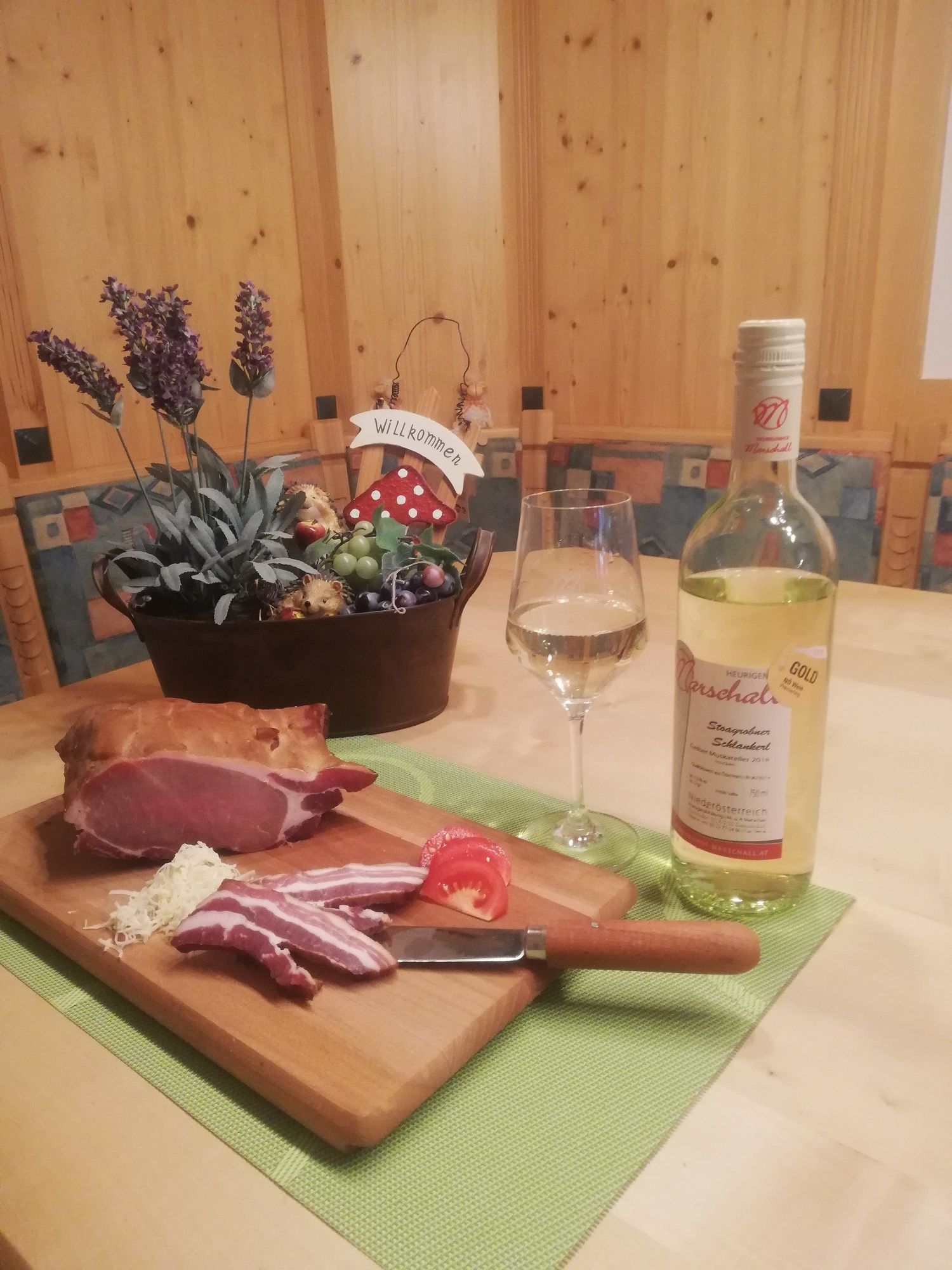 A table with ham, wine and decoration.