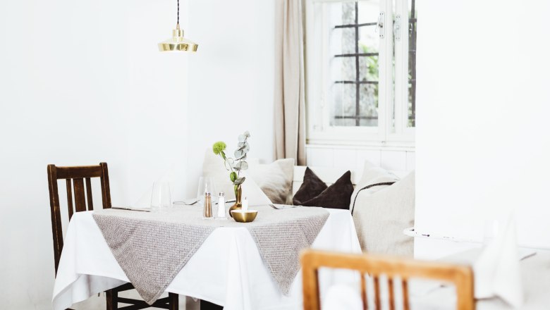 Comfortably furnished restaurant with wooden furniture and table decorations.