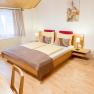 Cozy guest room with double bed, wooden furniture and decoration.