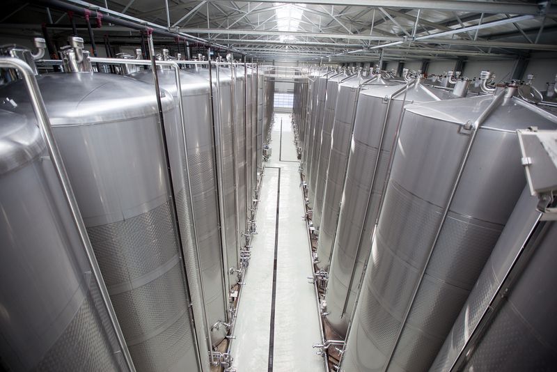 Large stainless steel tanks in a modern wine production hall.