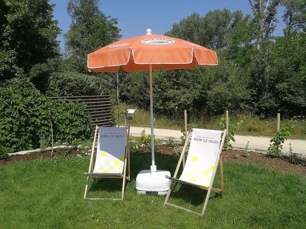 two sun loungers with parasol in the garden of the garden vinotheque 