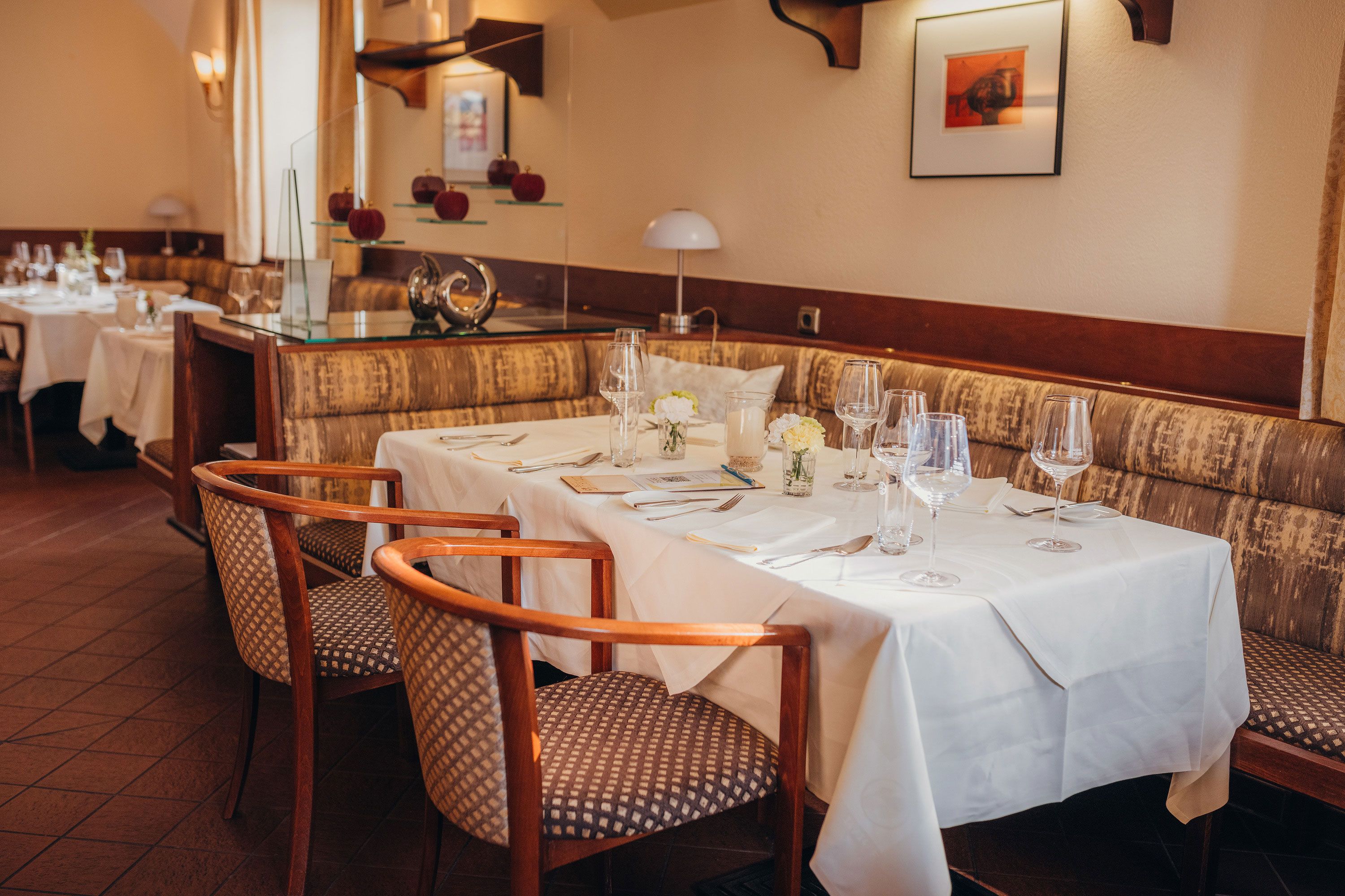 Elegant restaurant with a table setting, white tablecloths and stylish chairs.