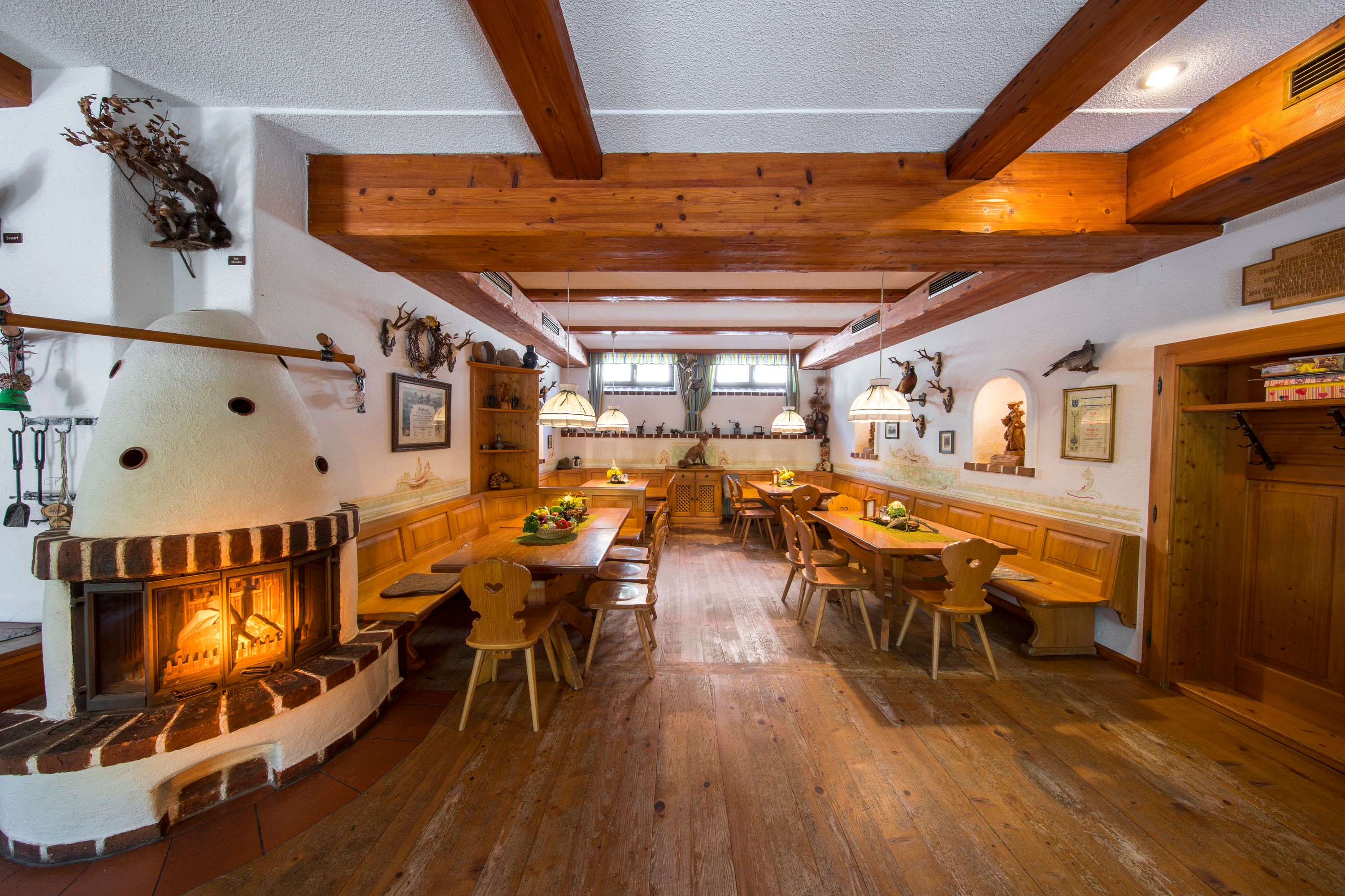 Cozy dining room with fireplace, wooden furniture and rustic decoration.