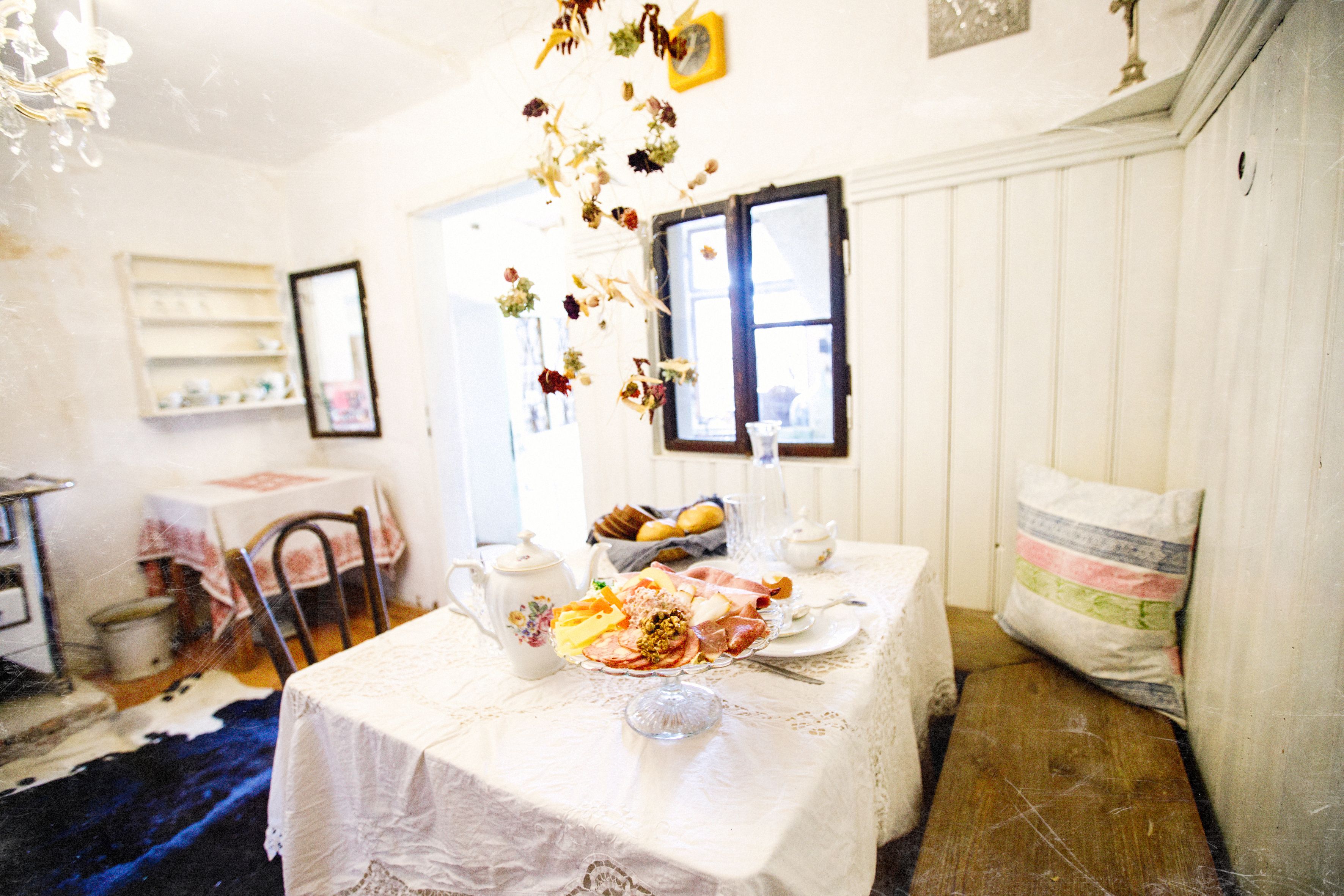 A cozy breakfast table set in a rustic room with white walls and wooden furniture.