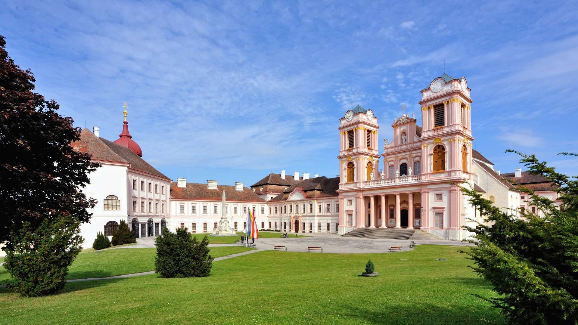 Göttweig Abbey with its baroque architecture and green forecourt under a blue sky.