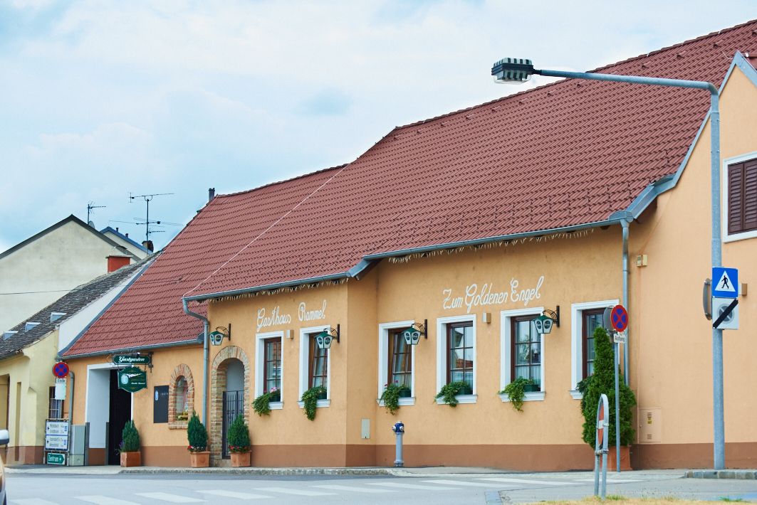 A traditional inn with a yellow façade and red roof, labeled 'Gasthaus Rammel' and 'Zum Goldenen Engel'.