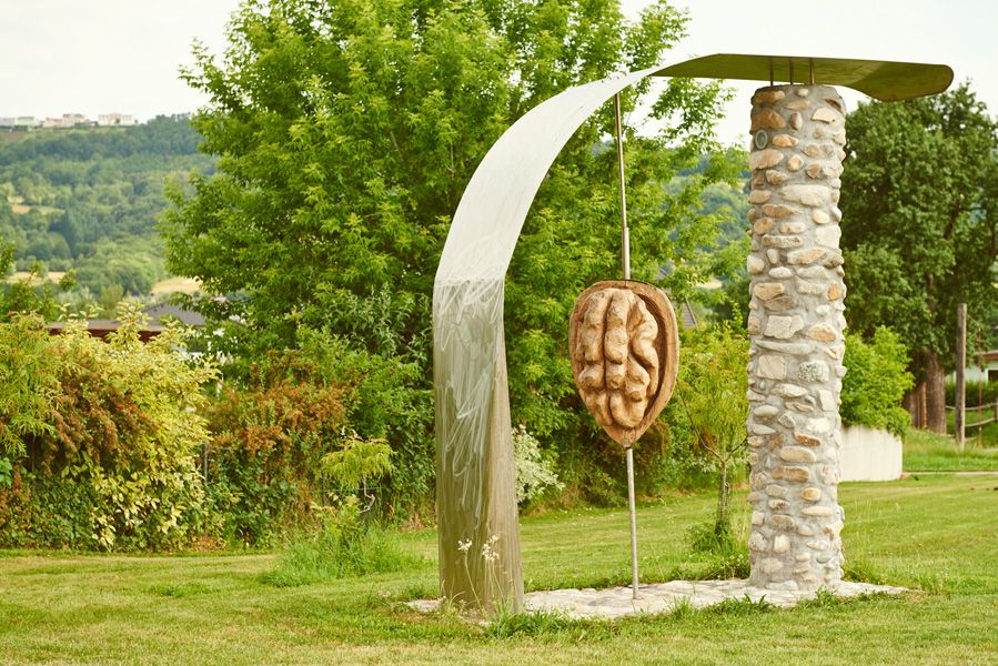 Sculpture of a walnut in Krummnußbaum, surrounded by trees and meadow.