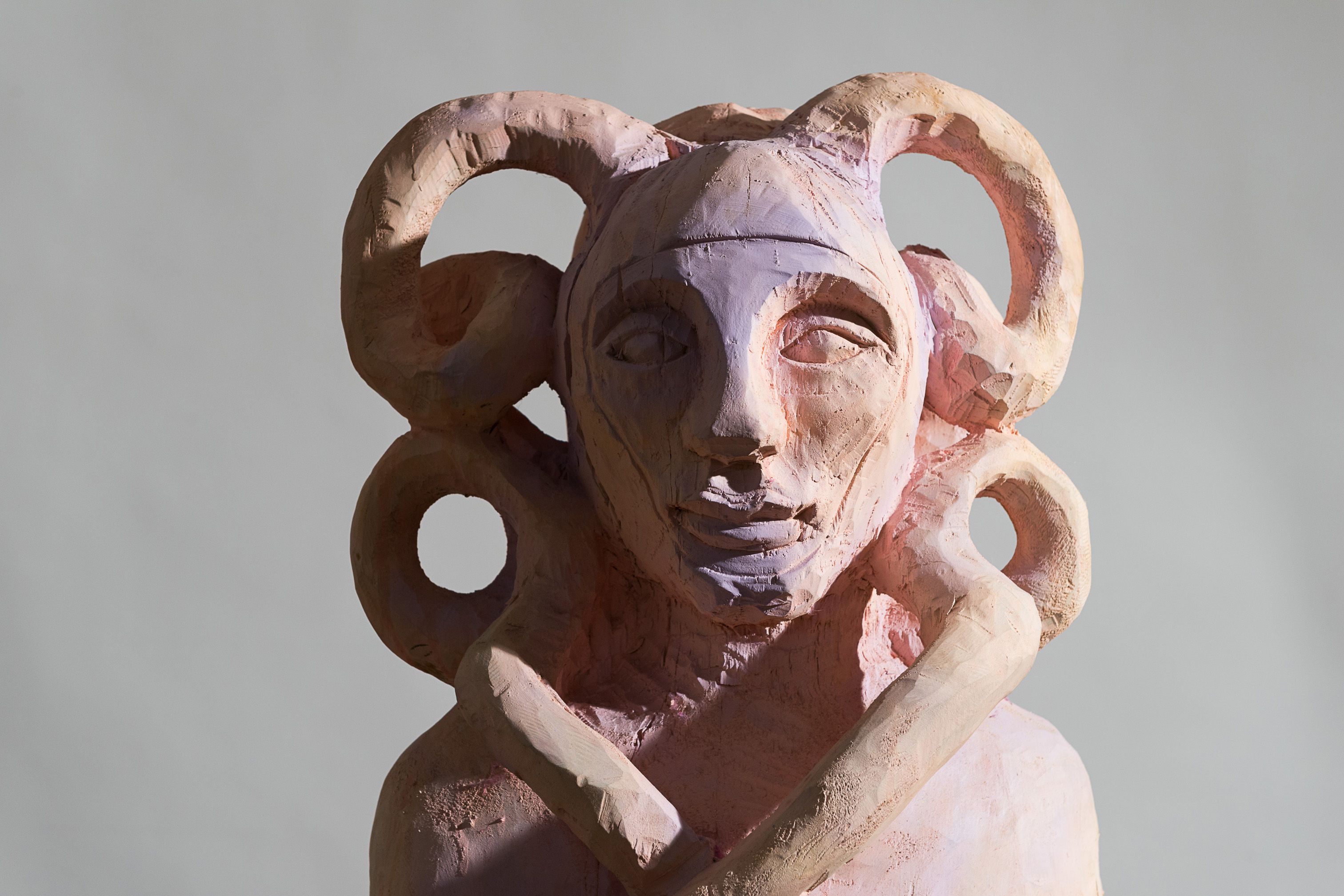 Sculpture with horns and abstract face.