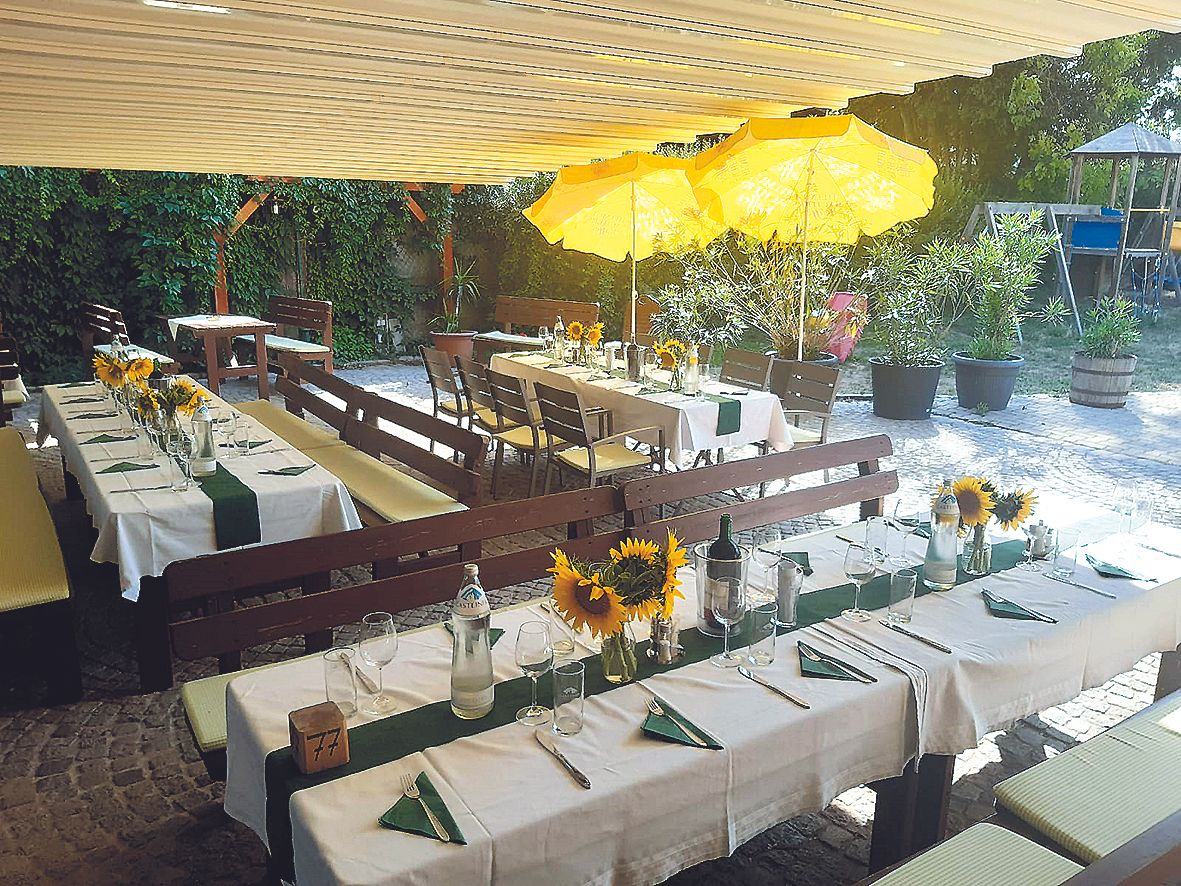 Outdoor tables set with sunflowers and yellow parasols.