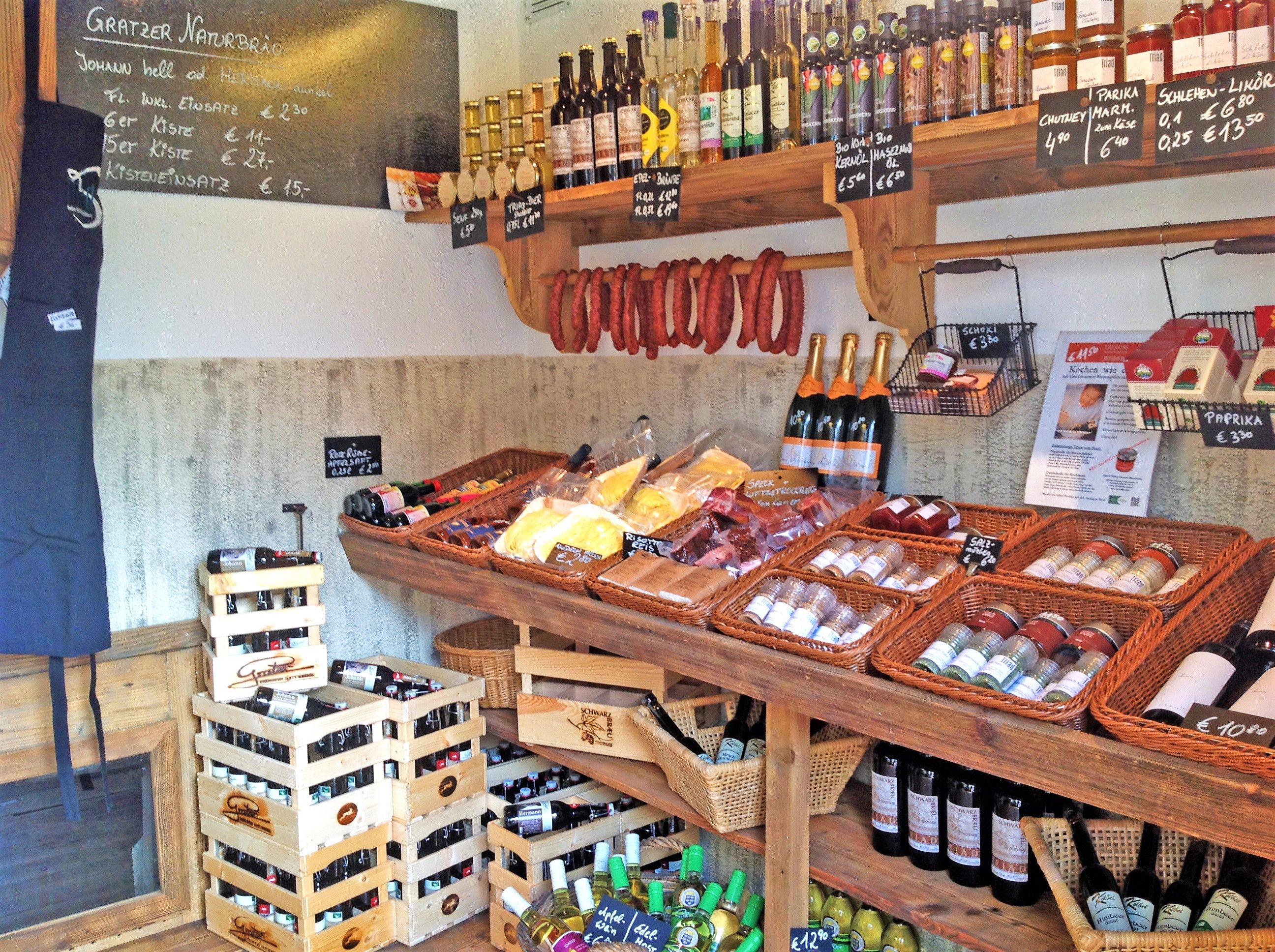 Interior view of a farm store with shelves full of regional products such as wine, sausage, spices and oil.