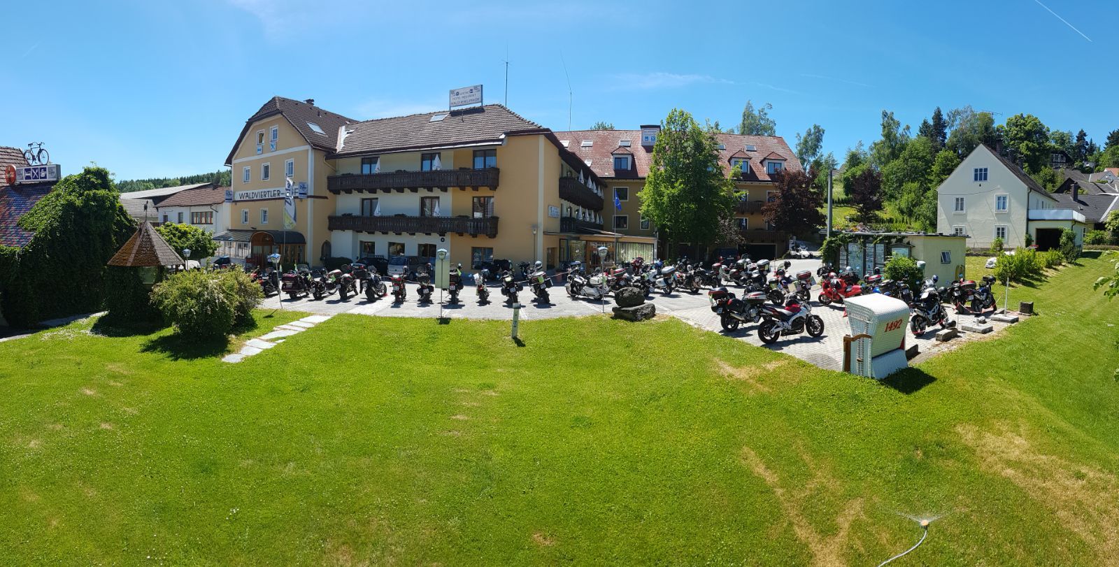 Hotel Waldviertler-Hof with many motorcycles parked in front of it.
