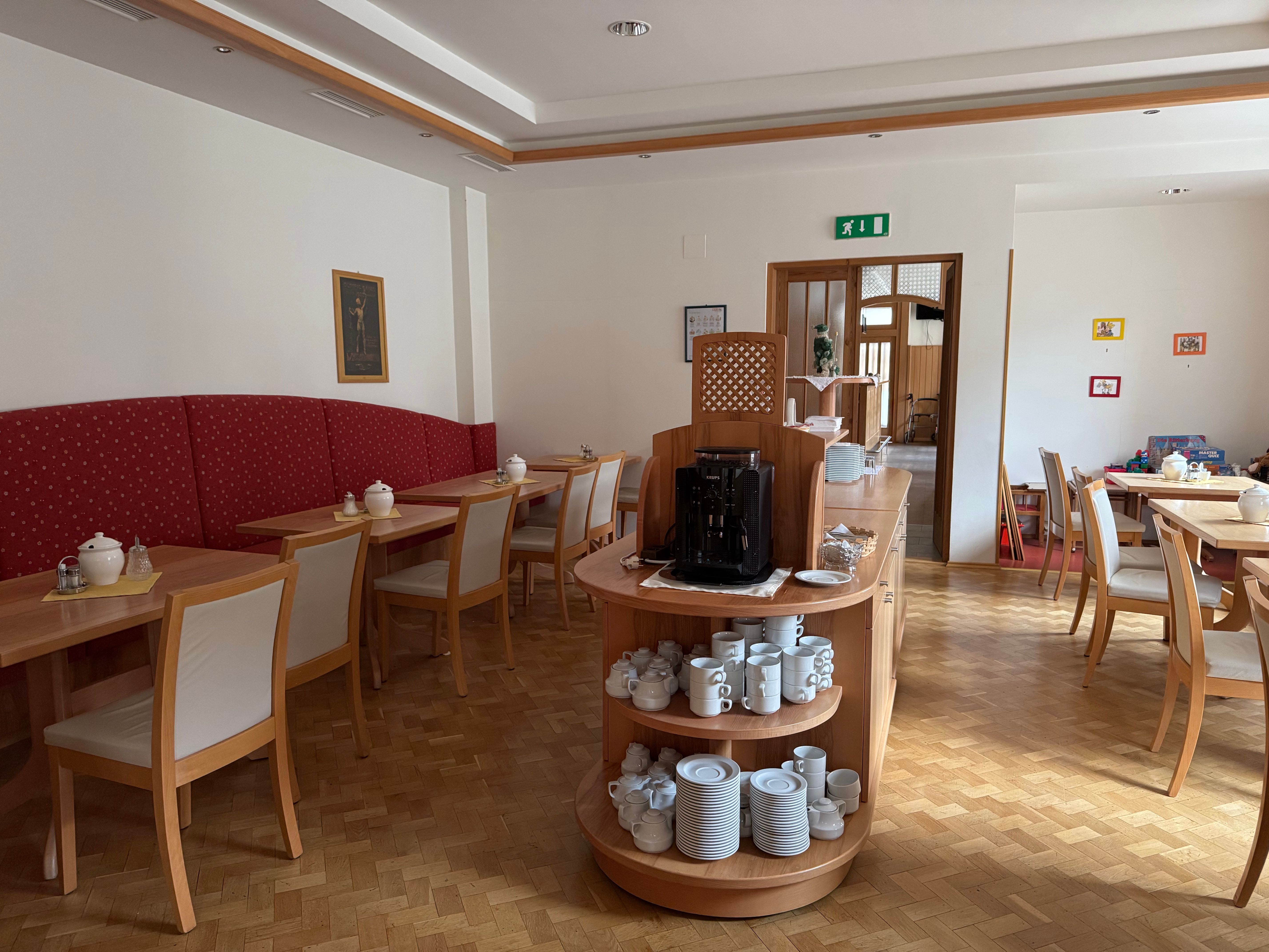 Interior view of a breakfast room with wooden furniture and crockery.