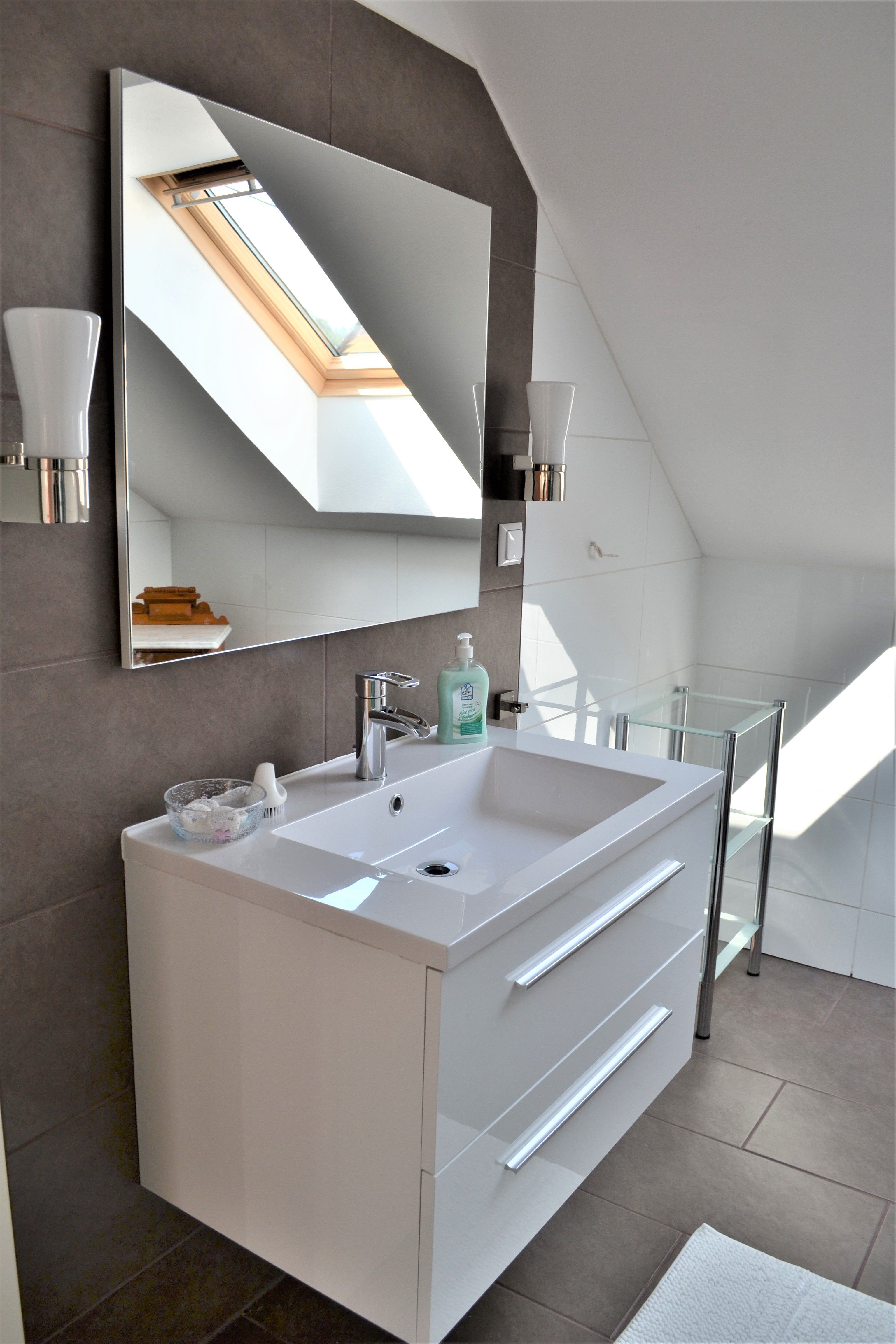 Modern bathroom with washbasin, mirror and skylight.