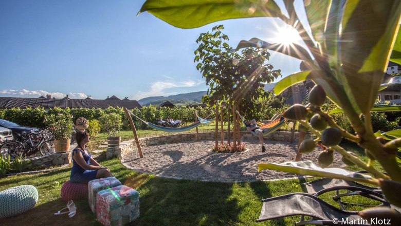 Mediterranean garden with hammocks and people relaxing.