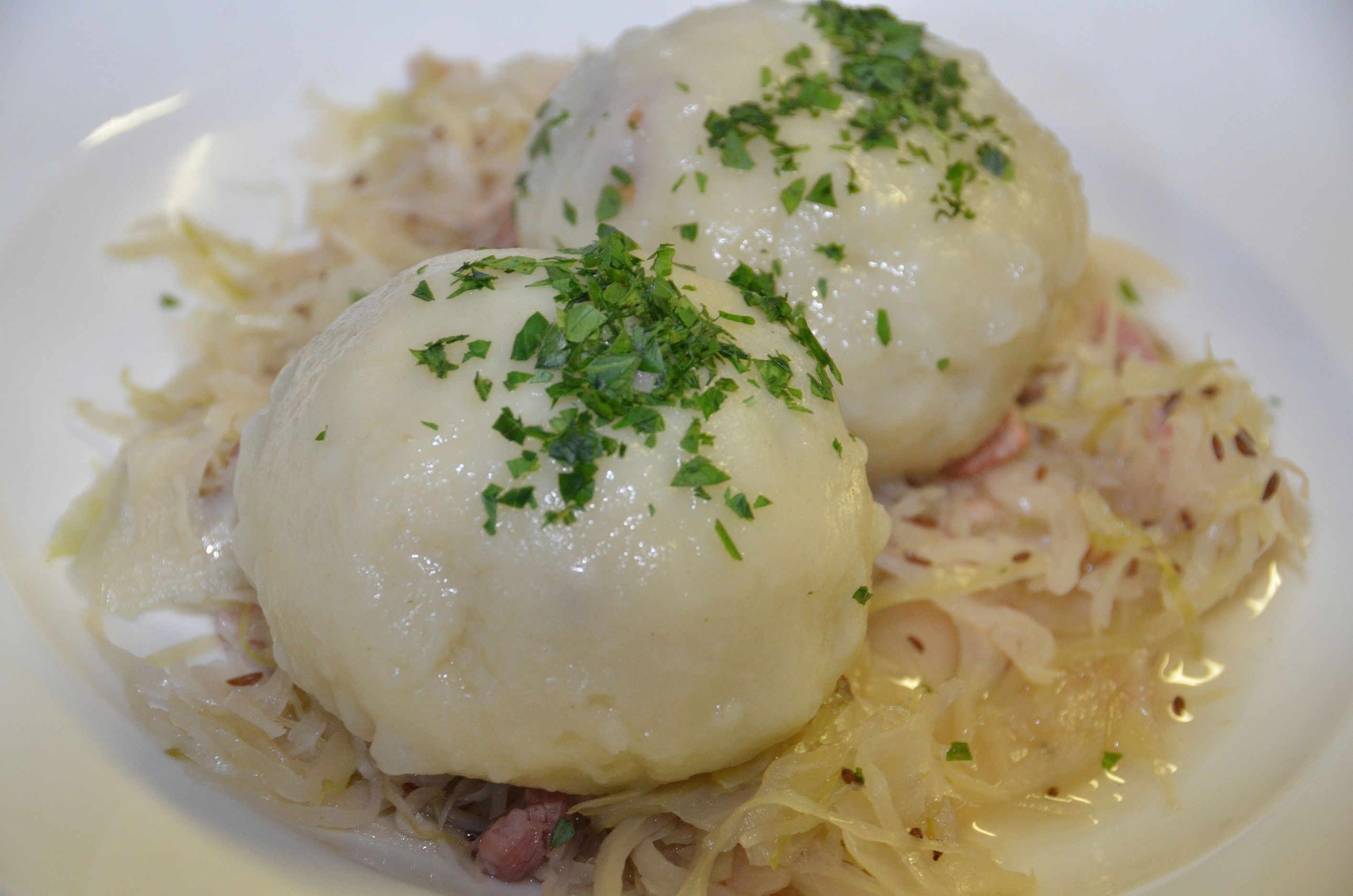 Two grammel dumplings on sauerkraut, garnished with parsley.