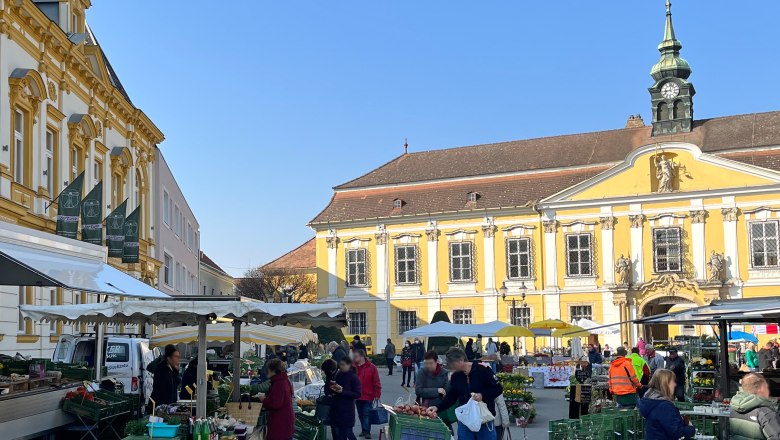 Weekly market in Stockerau with historic buildings in the background.