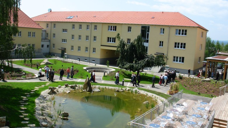 Inner courtyard with pond, seating area and people.