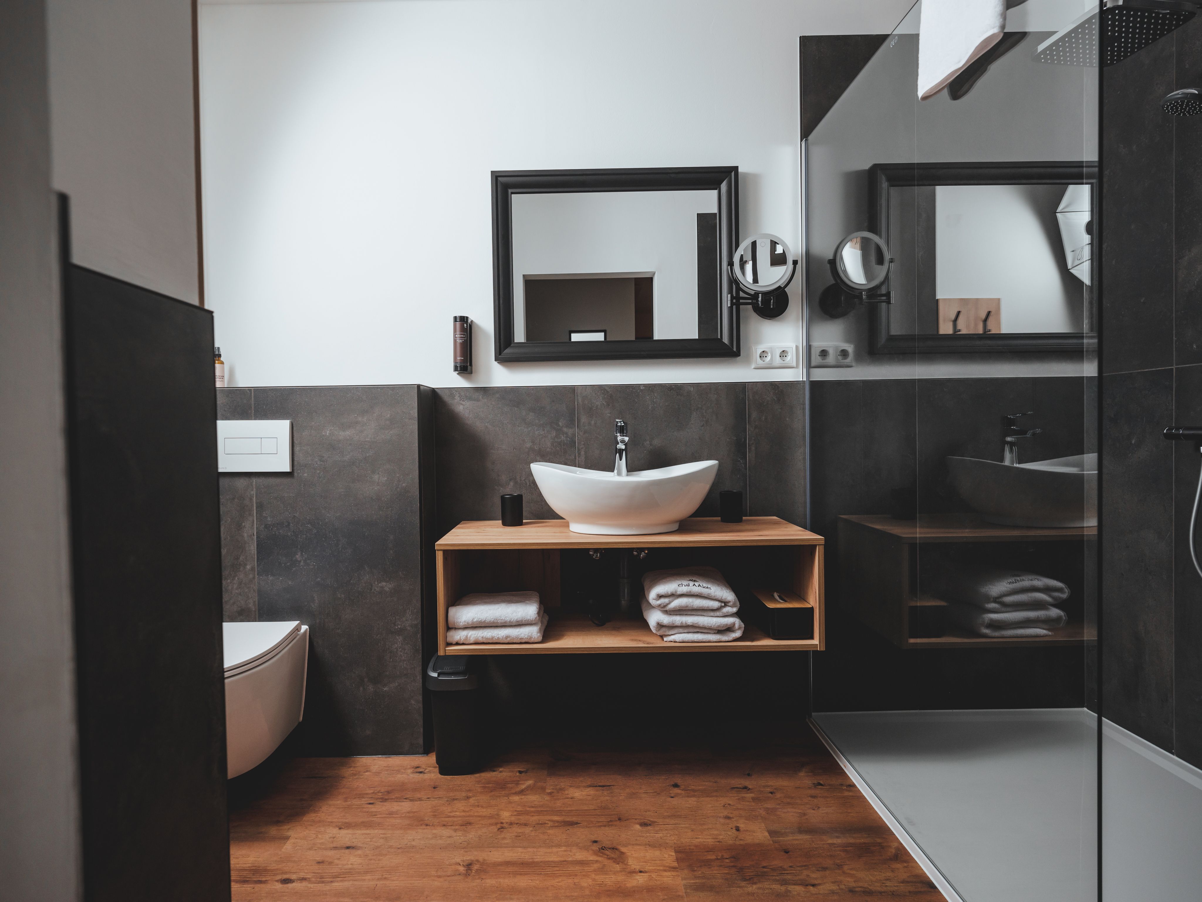 Modern bathroom with washbasin, mirror, toilet and shower.