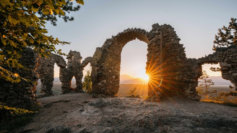 Ruins of the Türkensturz at sunset with sunlight shining through the stone arches.
