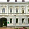 Historic building with ornate windows and an archway.