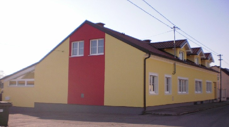 Exterior view, © © Bianca Waysmayer Exterior view of a yellow-red building with several windows and a pitched roof.