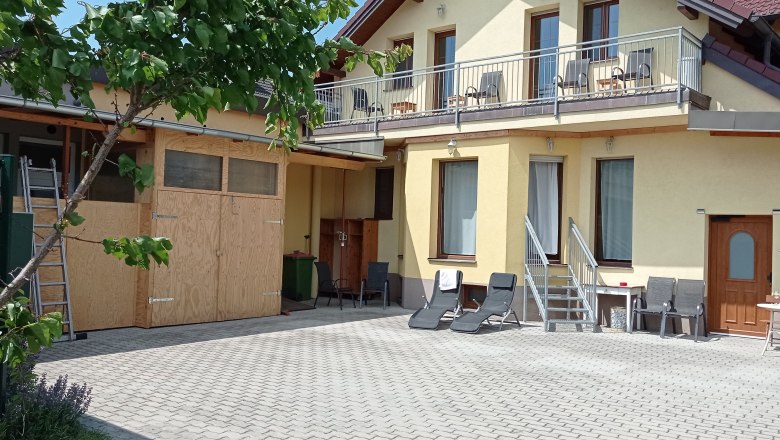 Haus von außen mit gelber Fassade und Balkon