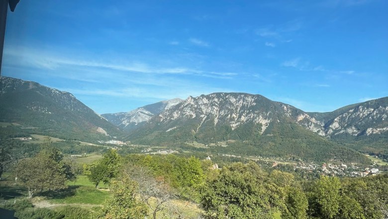 View of a mountain landscape with a blue sky and green meadows.