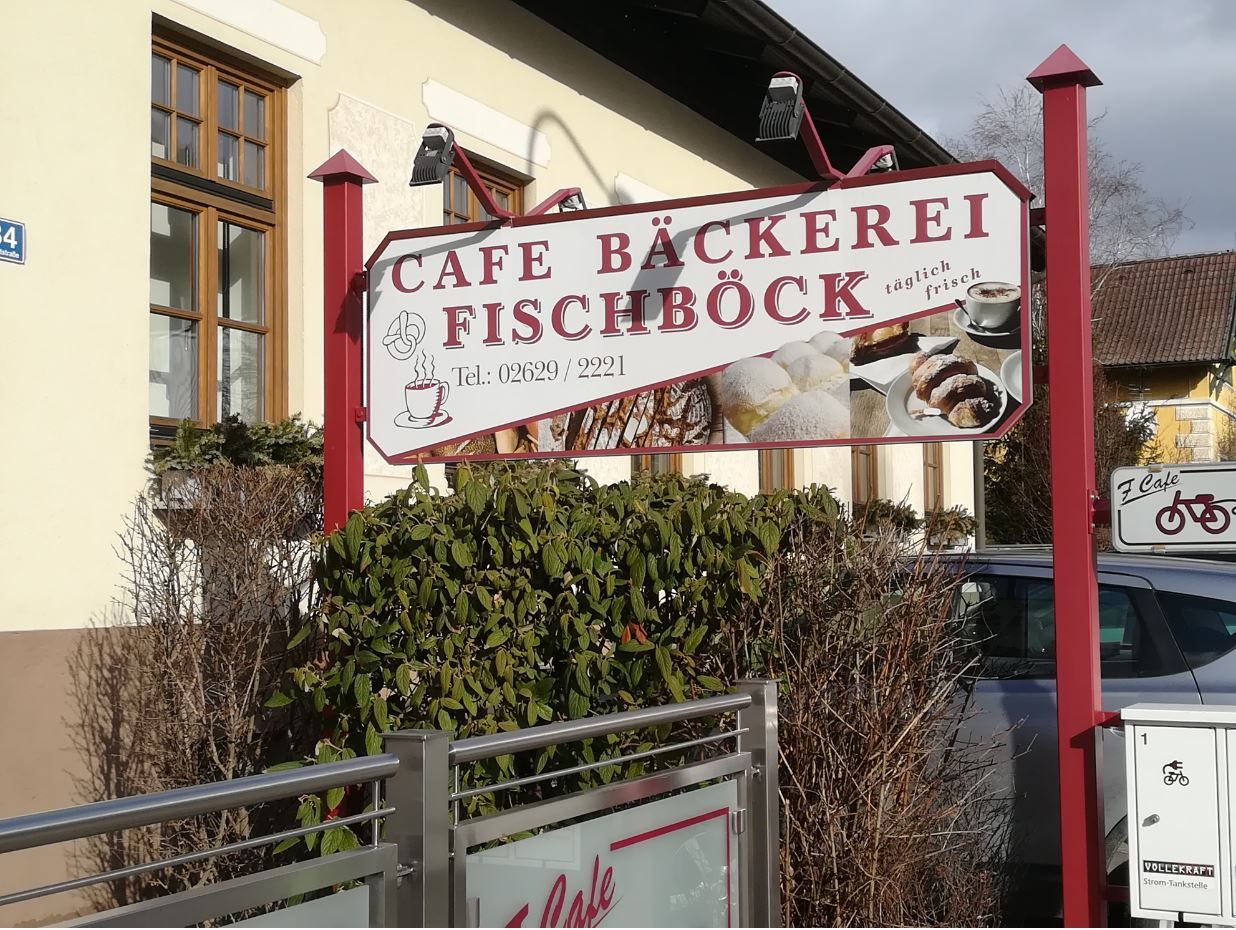 Sign of Café-Bäckerei Fischböck with pictures of pastries and telephone number.