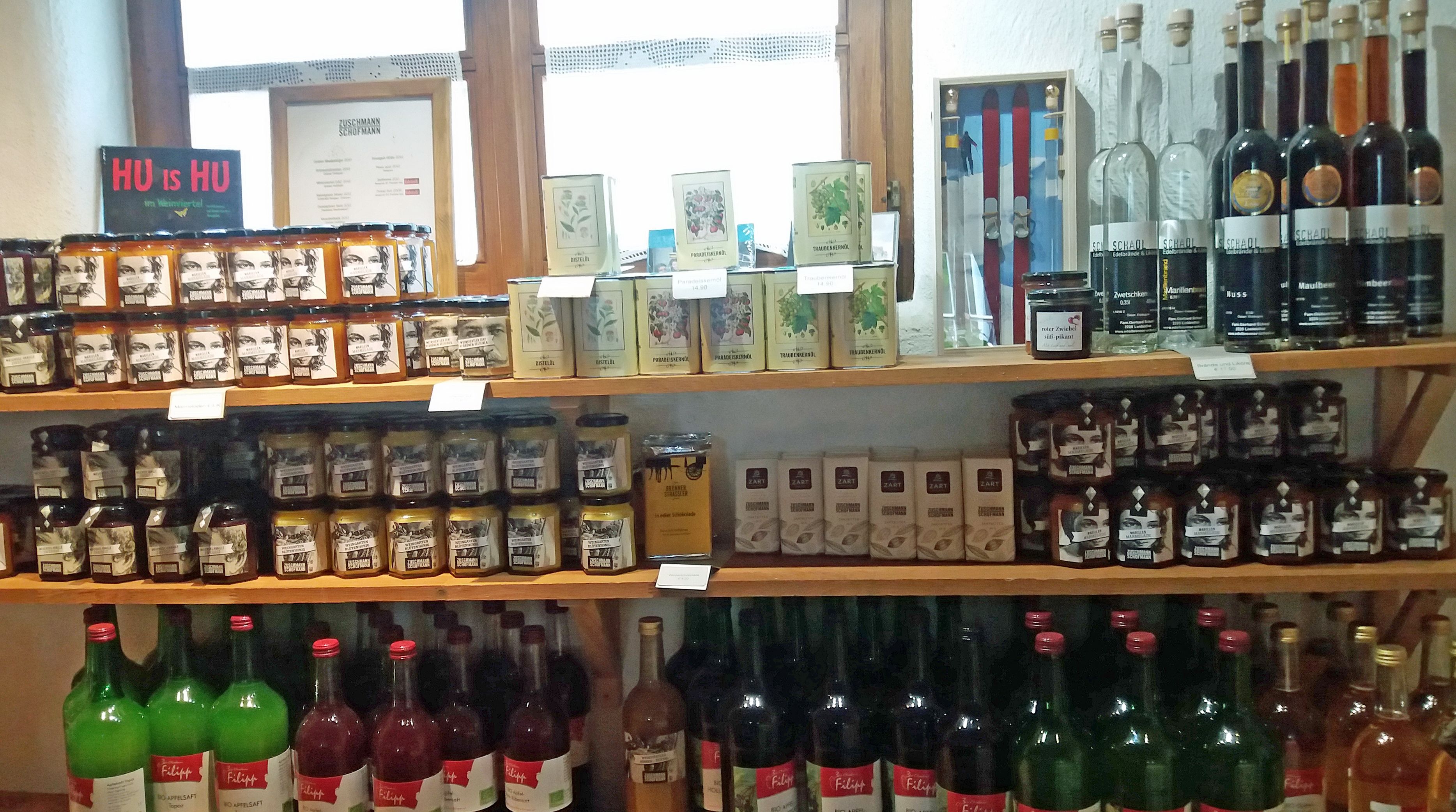 Shelf with various foods such as jams, teas and drinks.