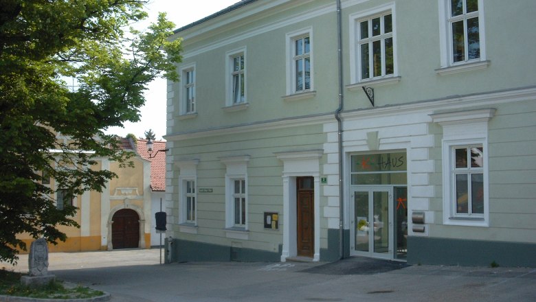 A two-story, light green building with the word 'house' above the door.